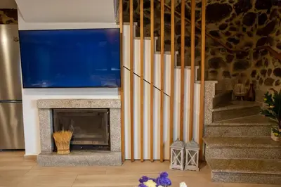 a living room with a fireplace with a large television at Villa Limia