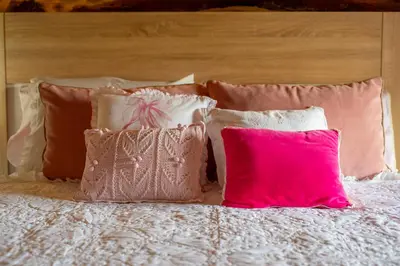 a bed with pink and white pillows on it at Villa Limia