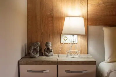 two little statues sitting on a nightstand next to a bed at Villa Limia