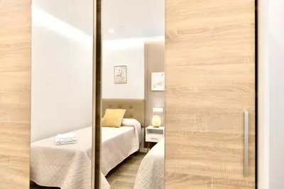 a room with two beds and a sliding glass door at Urban Essences by Lugo Collection in Lugo