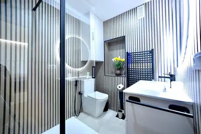 a bathroom with a white toilet and a sink at Urban Essences by Lugo Collection in Lugo