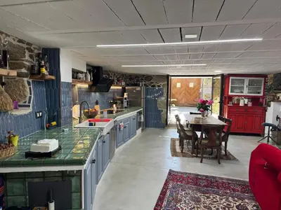 a kitchen with a table and a dining room at Casa Vella do Nanín in Faramontaos
