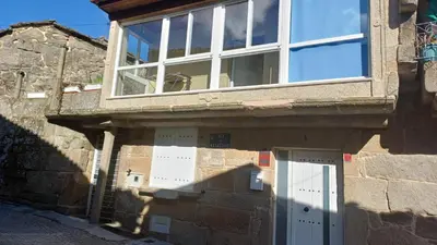 a building with a large window and a door at Casa Diaz in Cea