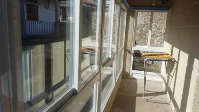 a porch with windows and a table and a chair at Casa Diaz in Cea