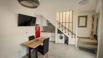 a kitchen with a dining room table and a staircase at Casa de Conxo in Santiago de Compostela