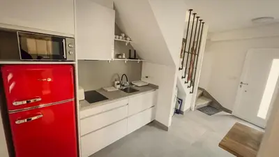 a red refrigerator in a kitchen with a staircase at Casa de Conxo in Santiago de Compostela