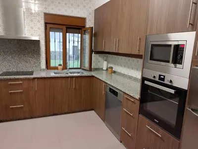 a kitchen with wooden cabinets and a microwave at Casa Las Catedrales Rochela in Devesa