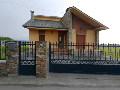 a small house with a black fence and a gate at Casa Las Catedrales Rochela in Devesa