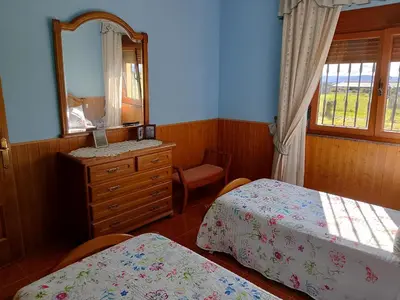 a bedroom with two beds and a dresser and a mirror at Casa Las Catedrales Rochela in Devesa