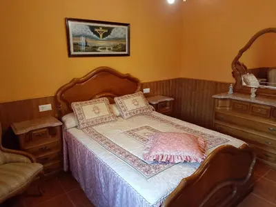 a bedroom with a bed with a wooden head board at Casa Las Catedrales Rochela in Devesa