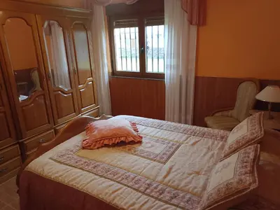 a bedroom with a bed and a chair and a window at Casa Las Catedrales Rochela in Devesa