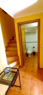 a bathroom with a toilet and a glass table at EnFOZ Duplex En La Playa in Foz