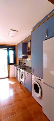 a kitchen with a stove and a washer and dryer at EnFOZ Duplex En La Playa in Foz
