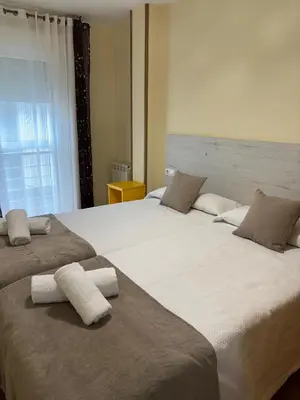 a bedroom with two beds with towels on them at Alojamiento Morriña in O Pedrouzo