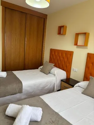 a hotel room with two beds with white sheets at Alojamiento Morriña in O Pedrouzo