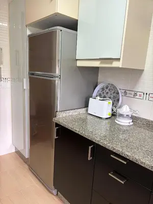 a kitchen with a stainless steel refrigerator and cabinets at Alojamiento Morriña in O Pedrouzo