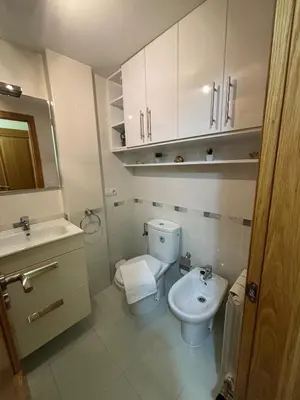 a white bathroom with a toilet and a sink at Alojamiento Morriña in O Pedrouzo