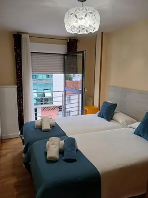 a bedroom with two beds with towels on them at Alojamiento Morriña in O Pedrouzo