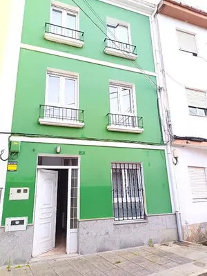 a green building with a white door and windows at Casa das Mariñas in Viveiro
