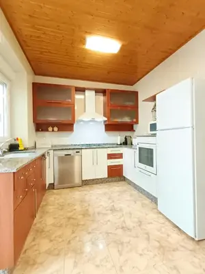 a kitchen with white appliances and a wooden ceiling at Casa das Mariñas in Viveiro