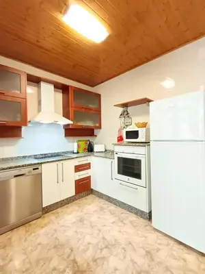 a kitchen with white appliances and a white refrigerator at Casa das Mariñas in Viveiro