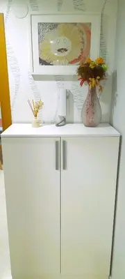 a white cabinet with a vase of flowers on it at EnFOZ Tus Mejores Vacaciones, Playa Piscina y Parking in Foz