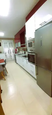 a kitchen with a stainless steel refrigerator and white cabinets at EnFOZ Tus Mejores Vacaciones, Playa Piscina y Parking in Foz