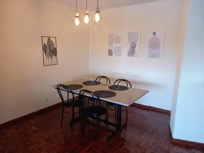 a table in a room with chairs and paintings at Puerto de Burela in Burela de Cabo