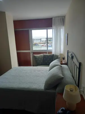 a bedroom with a large bed and a window at Puerto de Burela in Burela de Cabo