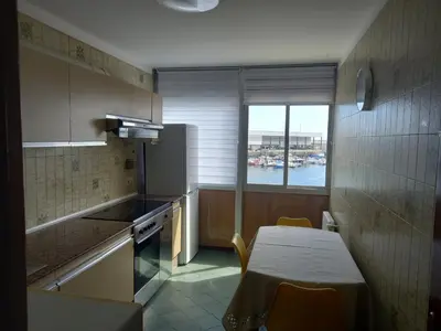 a kitchen with a table and a table and a window at Puerto de Burela in Burela de Cabo