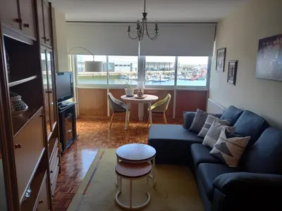 a living room with a blue couch and a table at Puerto de Burela in Burela de Cabo