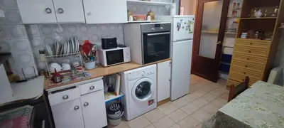 a kitchen with a washing machine and a microwave at Rosalia Rooms in A Estrada
