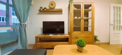 a living room with a television and a table at EnFOZ Playa A Rapadoira in Foz