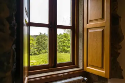 an open window with a view of a green field at A Casa do Carpinteiro