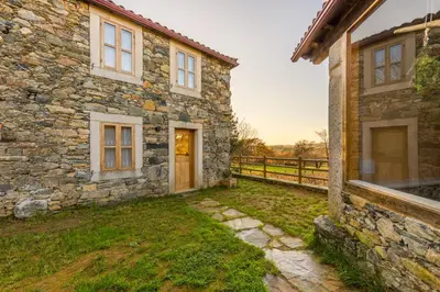 an old stone house in a yard at A Casa do Carpinteiro