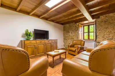 a living room with a couch and a tv at A Casa do Carpinteiro