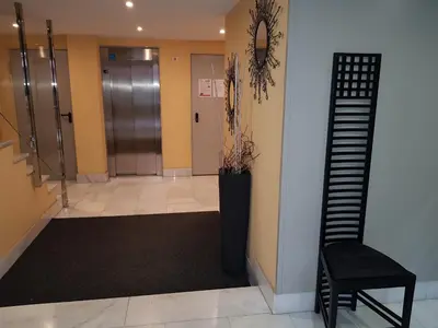a hallway with a black chair and a staircase at Alojamiento Misericordia in Viveiro