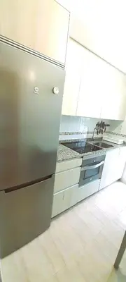 a kitchen with a stainless steel refrigerator and a sink at EnSAN CIPRIAN Con Playa Piscina y Parking in San Ciprián