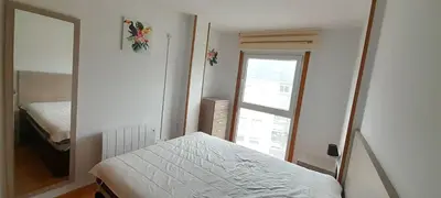 a small bedroom with a bed and a mirror at EnSAN CIPRIAN Con Playa Piscina y Parking in San Ciprián
