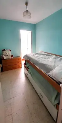 a bedroom with a bed and a blue wall at EnSAN CIPRIAN Atico en Urb Río Cobo in San Ciprián