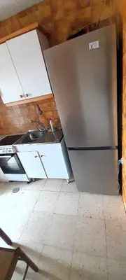 a kitchen with a refrigerator and cabinets in a room at EnSAN CIPRIAN Atico en Urb Río Cobo in San Ciprián
