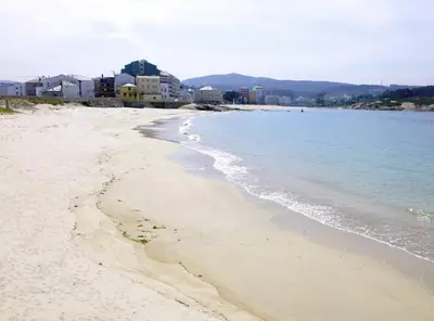 a sandy beach with buildings and the ocean at EnSAN CIPRIAN Atico en Urb Río Cobo in San Ciprián