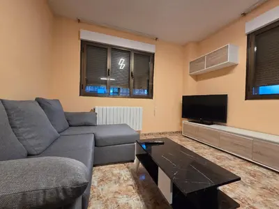 a living room with a couch and a flat screen tv at Casa Alba in Puebla de Sanabria