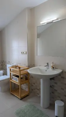 a bathroom with a sink and a mirror and a toilet at Cantiño 39 in Lugo