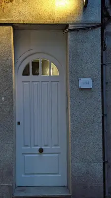 a white door in the side of a building at Cantiño 39 in Lugo