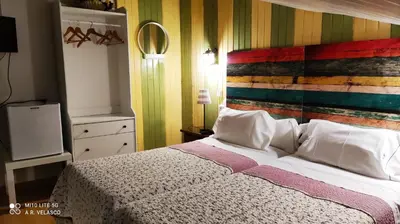 a bedroom with a bed with a colorful wall at Hostal Martin - Sanabria in Ribadelago