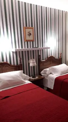 a hotel room with two beds and a striped wall at Hostal Martin - Sanabria in Ribadelago