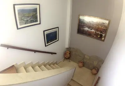a room with a staircase with paintings on the wall at Hostal Martin - Sanabria in Ribadelago