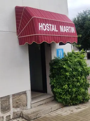 a hospital entrance with a red awning on a building at Hostal Martin - Sanabria in Ribadelago