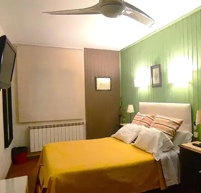 a bedroom with a yellow bed and a ceiling fan at Hostal Martin - Sanabria in Ribadelago